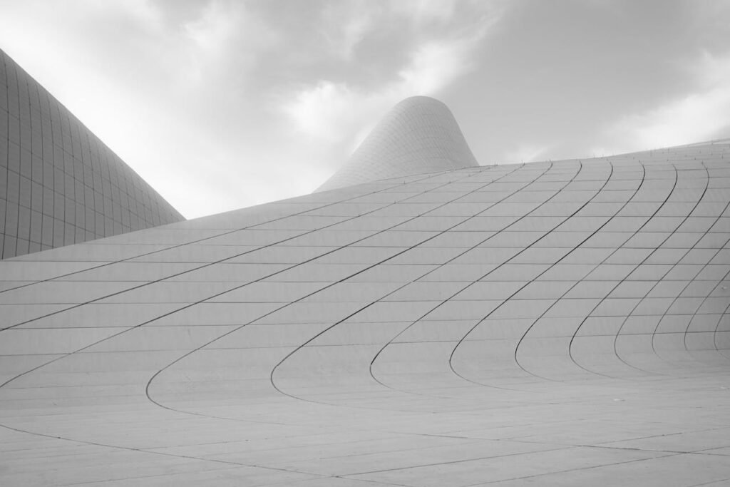 Crafting Captivating Headlines: Your awesome post title goes here Sleek curves of Heydar Aliyev Center's exterior showcasing modern architectural design in black and white.